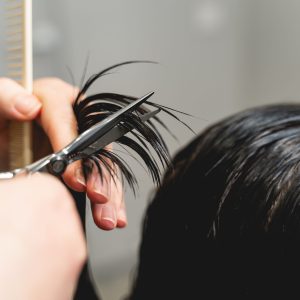 New hairstyle. Kind hairdresser using sterile instruments while serving her client in salon. Beauty concept