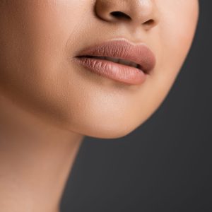 Cropped view of young woman with makeup isolated on grey