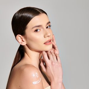 A young woman with brunette hair showcases her skins uniqueness and beauty in an intimate studio setting.